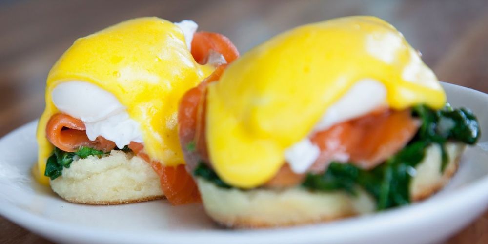 Eggs royale, smoked salom and spinach crumpets on a white plate, the perfect festive Easter brunch recipe.