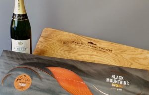 Add-Champagne-300×191 A bottle of champagne with a smoked salmon side on an oak platter