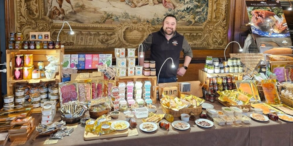 Simon from Black Mountain Smokery showcasing a selection of smoked goods at a city Christmas fair stall